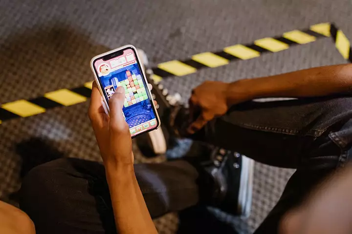 A man is playing candy Crush game with his smartphone