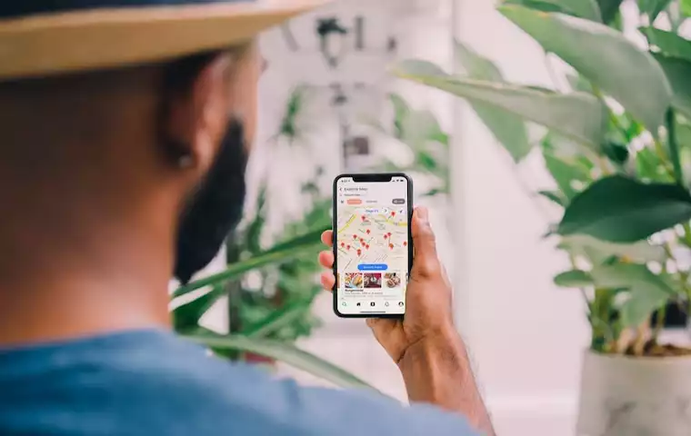 A man is looking at his smartphone showing a map